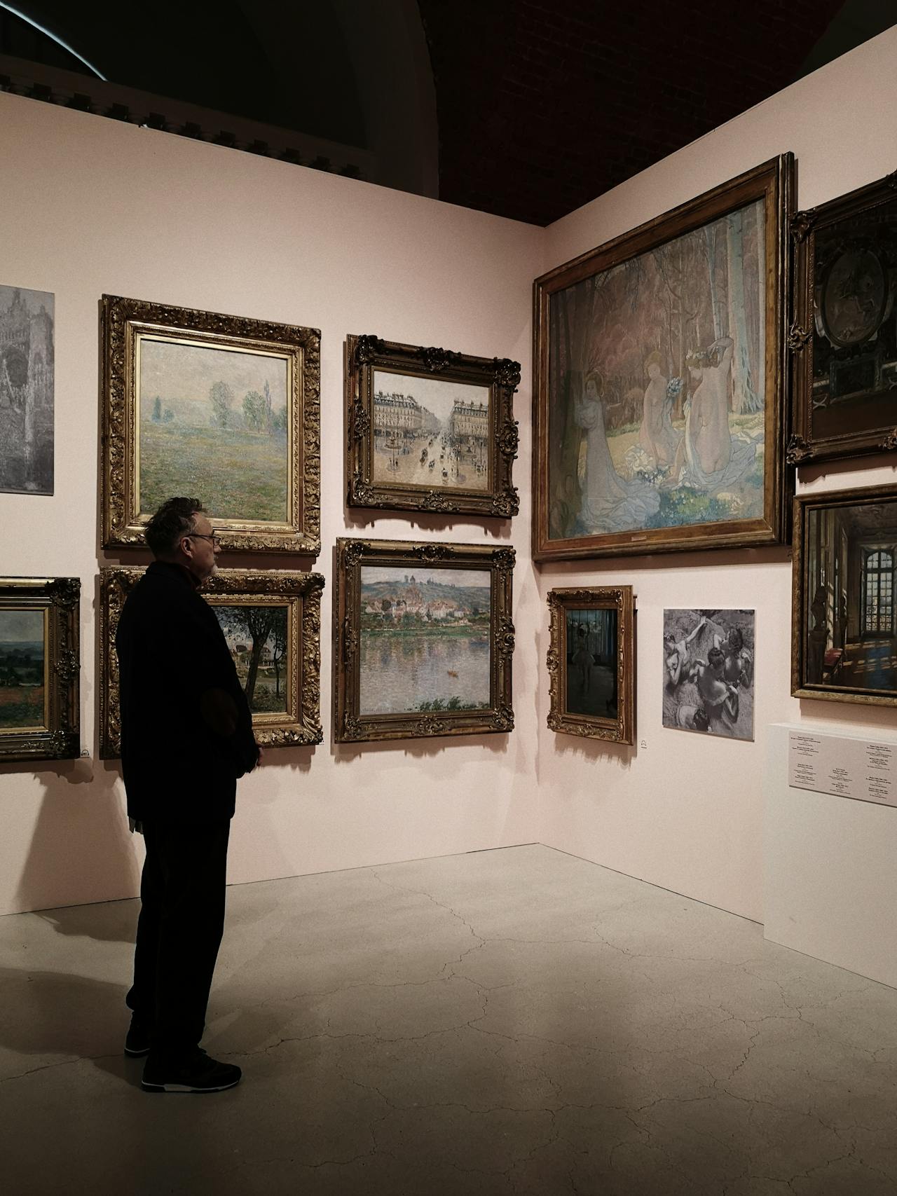 man looking at art that has been hung